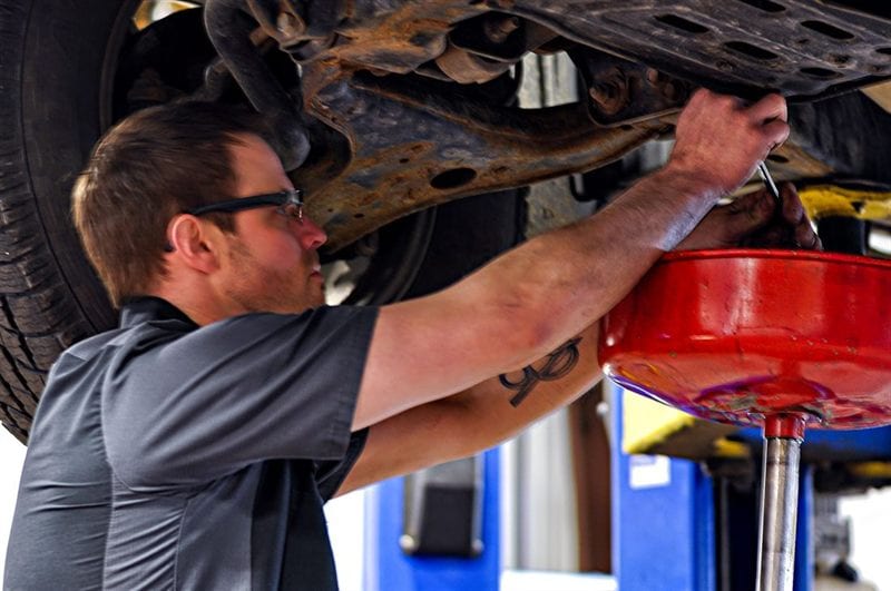 Mechanic performing an oil change at Corey's Car Care Center auto repair shop in Fargo, ND